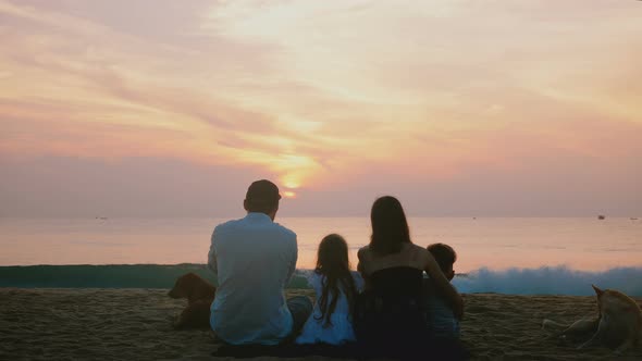 Amazing Back View Shot of Happy Travelers Family with Two Dogs Sitting Together at Amazing Tropical