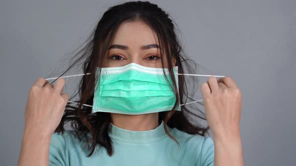 woman removes a medical mask (surgical mask) and smiling