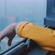 Young man wearing yellow raincoat stretches out his arm of the window - VideoHive Item for Sale