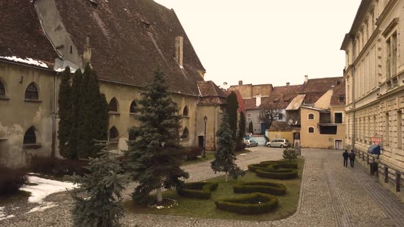 A static drone shot, capturing a glimpse of a closed locality in the city of Sighisoara on an aftern