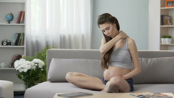 Future Mother Sitting on Sofa and Massaging Neck and Shoulders, Tensed Muscles