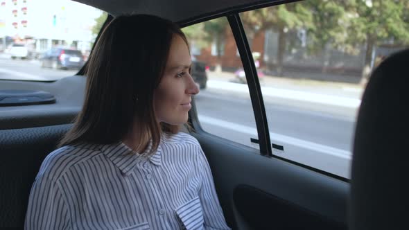 Brunette Girl Rides in Taxi in Backseat Enjoying the Ride