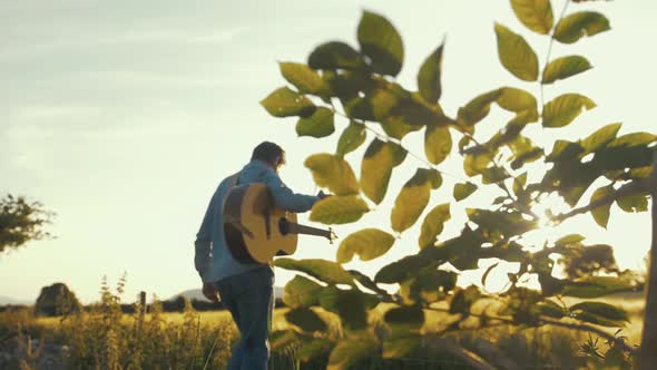 Musician rehearsing in wheat field during beautiful sunset