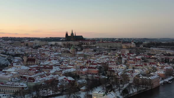 Prague Castle in Winter Twilight. Aerial View of St. Vitus Cathedral Silhouette and Snow Capped City