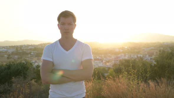 Young Handsome Tourist Man Smiling On The Hill Against Sunlight