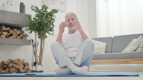 Old Man Listening Music on Headphones and Meditating