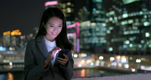 Businesswoman use of cellphone in city at night