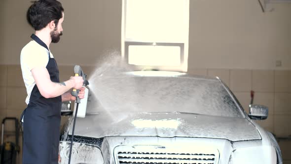 Man Washing His Car in a Garage