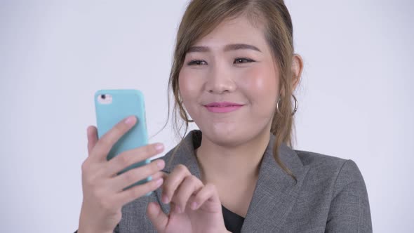 Face of Young Happy Asian Businesswoman Using Phone