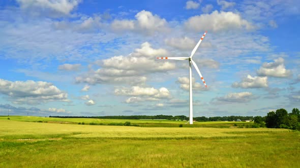 Wind turbines with blue sky on green field, view from above in summer