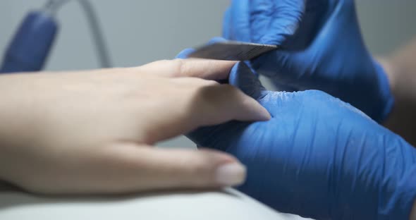 Master Hand Sawing Nails with Fingers and File Closeup