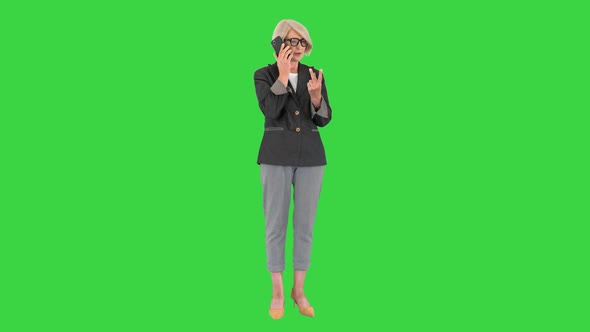 Aged Serious Senior Woman Talking on the Phone on a Green Screen Chroma Key