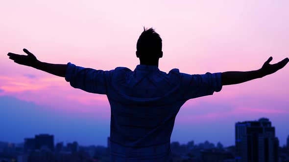 Man Raising Hands on Sunrise Background, Freedom and Inspiration, Back View