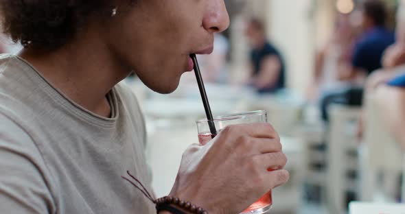 Man Drinking Cocktail at Happy Hour Aperitif in City cafe.Spritz cocktail.Medium Portrait Shot