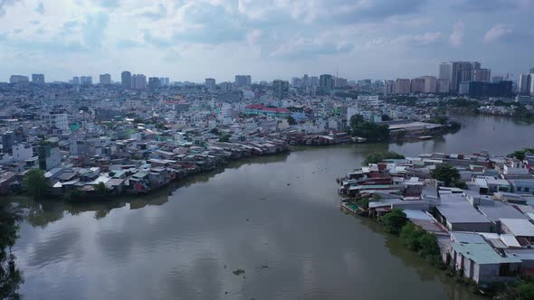 Aerial fly in shot of urban canal, reflection and high density waterfront housing and factories in H