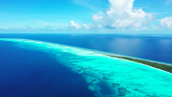 Beautiful flying tourism shot of a sunshine white sandy paradise beach and aqua blue water background