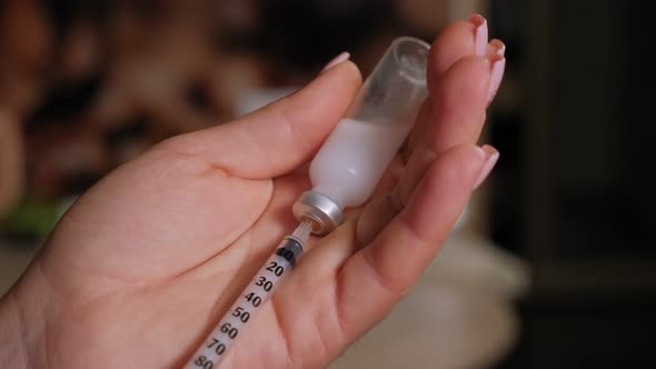 Woman Diabetic with a Syringe and Insulin in Hand Closeup