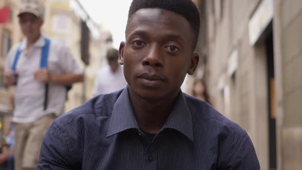 Young sad african american man looks at the camera in the street