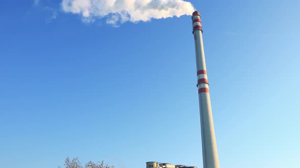 A Smokestack Emits Smoke - the Clear Blue Sky in the Background