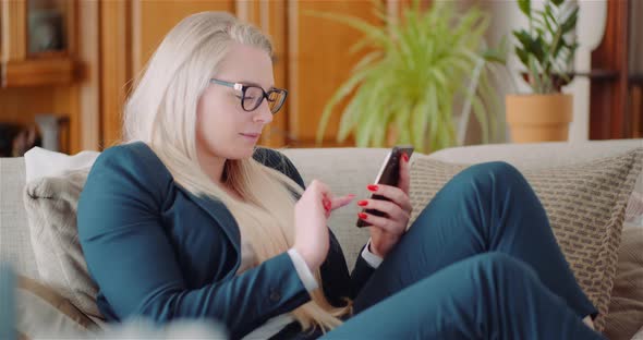 Businesswoman Using Mobile Phone On Sofa