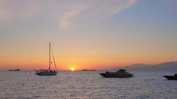 Sunset in Mykonos, Greece with and Yachts in the Harbor