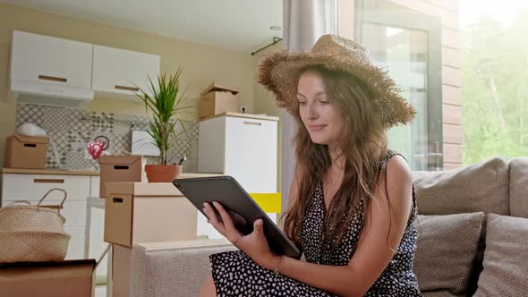 Woman Using Tablet with Boxes at the Back. Portrait of Young Beautiful Woman with Mobile Phone in