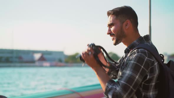 Attractive asian man tourist walking traveling with nose ring taking photo on camera at the pier