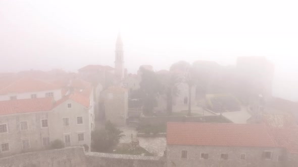 Buildings and Trees of the Old Town of Budva in the Fog