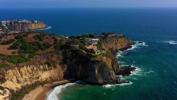 Drone shot flying towards a massive mansion on a cliff in Laguna Beach California