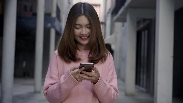 Asian tourist blogger woman using smartphone for direction and looking on location map.