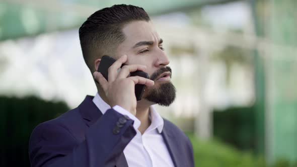 Businessman Talking By Cell Phone and Looking Away Outdoor