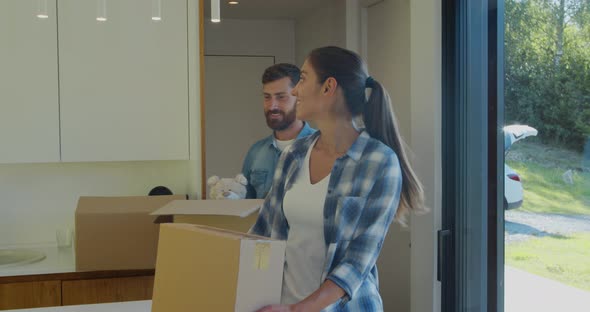 Couple Carrying Boxes Into New Home On Moving Day.