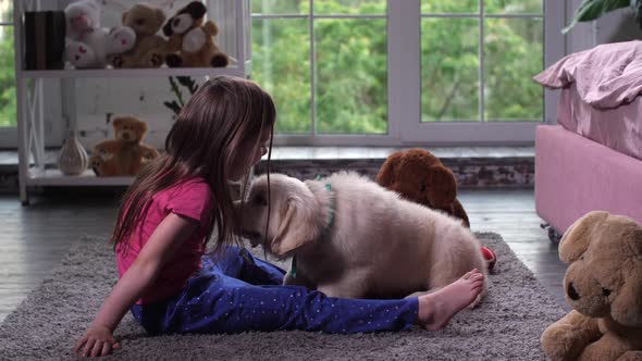 Little Child Having Fun with Puppy Pet on Carpet