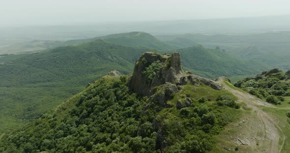 The medieval Azeula Fortress and a foggy, green wilderness in the background.