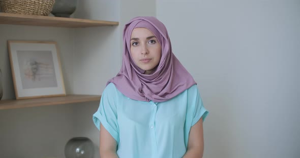 A Woman in a Hijab Looks Into the Camera and Silently Nods Her Head and Listens. Conversation Via
