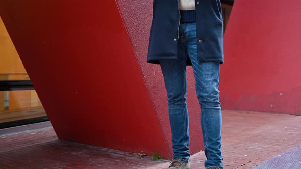 Tilt Up of Shot of Young Handsome Man Standing Near Red Office Building, After Work, Smiling Looking