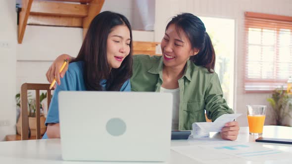 Business Asian Lesbian lgbtq women couple do account at home.