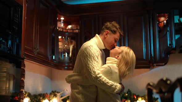 Side View Cheerful Loving Adult Couple Rubbing Noses Dancing at Home in Kitchen