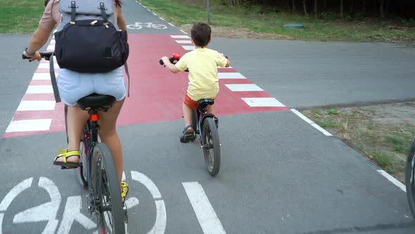 Family on bicycles passing red crossing