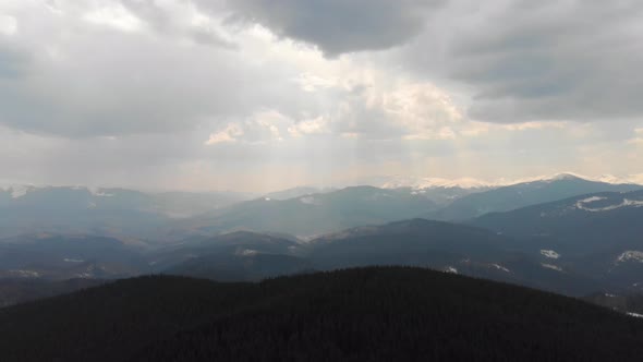 Sun in Clouds Over Mountain Ridges