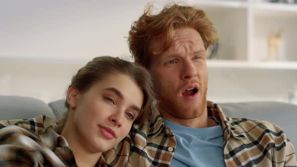 Young Couple Watching Boring Film at Home Closeup