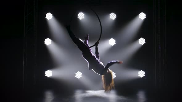 Beautiful Gymnast Hangs Upside Down on the Aerial Hoop and Performs the Acrobatic Elements