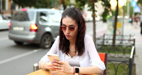 Young Woman with Glasses Uses the Phone