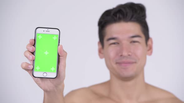 Face of Happy Young Shirtless Muscular Man Showing Phone