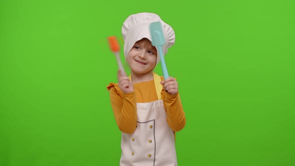 Child Girl Dressed in Apron Like Chef Cook Dancing Spatula on Chroma Key Background Slow Motion