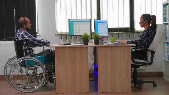 Man in Wheelchair Using Headset Making Telemarketing