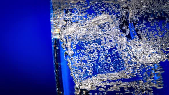 Glass of Water with Ice on a Dark Blue Background