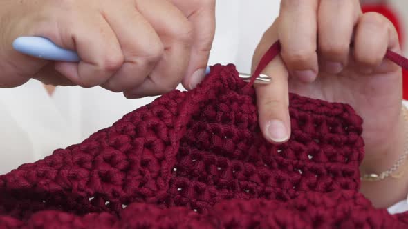 Closeup of Mature Woman's Hands Knitting with Yarn