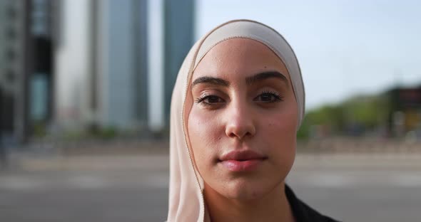 Muslim business woman working outside of the office with city in background