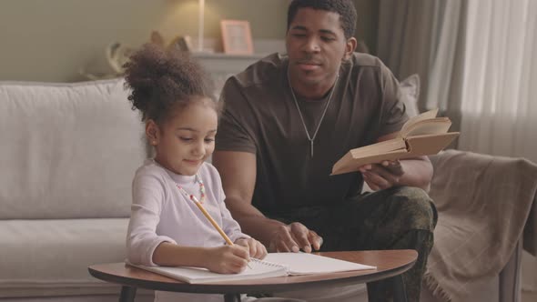 Military Father Helping Little Daughter with Homework alt